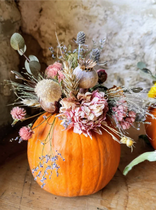 A Pumpkin displaying a range of dried, pale pink florals by Little Paddock Flowers